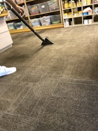 a person cleaning a carpet in a library