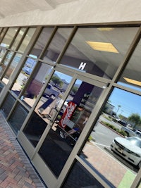 a store with a glass door and a parking lot in the background