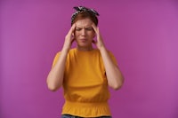 a young woman with her hands on her head